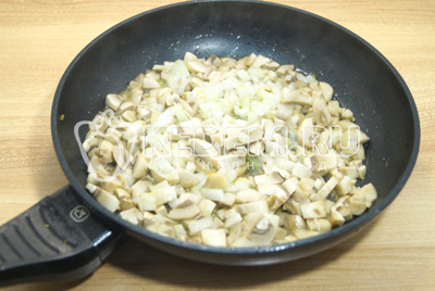 На сковороде с растительным маслом обжарить мелко нашинкованный лук и грибы.