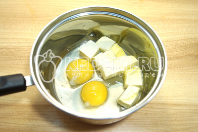 В сотейник разбить яйца и добавить сливочное масло.