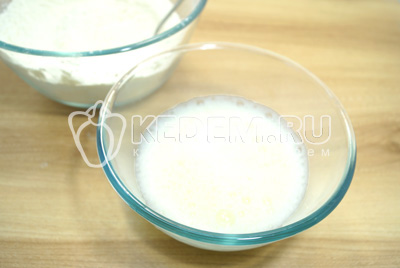 В большую миску просеять муку, добавить соль и круговыми движениями влить яйцо с водой и растительным маслом.
