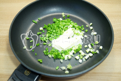 На сковороде со сливочным маслом обжарить мелко нашинкованный зеленый лук.