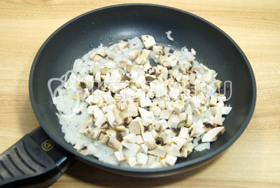 На сковороде с 2 столовыми ложками растительного масла обжарить грибы с луком.
