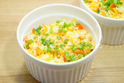 Выложить рис с овощами выложить в миски и посыпать мелко нашинкованным зеленым луком.