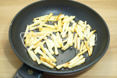 Обжарить картофель на сковороде с растительным маслом до золотистой корочки.