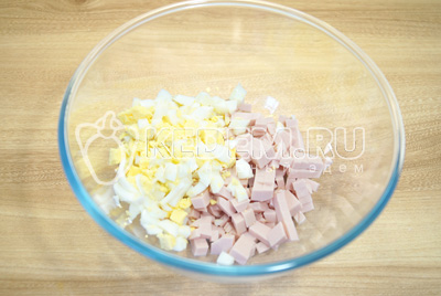 В миску нарезать кубиками вареную колбасу и яйца.