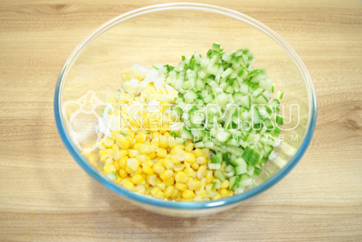 Добавить консервированную кукурузу и кубиками нарезанный свежий огурец.
