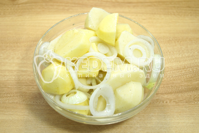 К картофелинам добавить полукольцами нарезанный лук и масло с солью и перцем. Хорошо перемешать и оставить на 10-15 минут.
