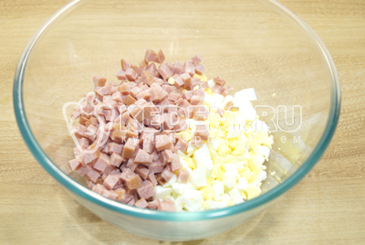 В миску нарезать кубиками яйца и добавить колбасу.