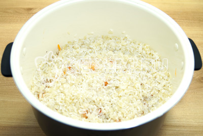 Добавить рис в один слой и залить водой.