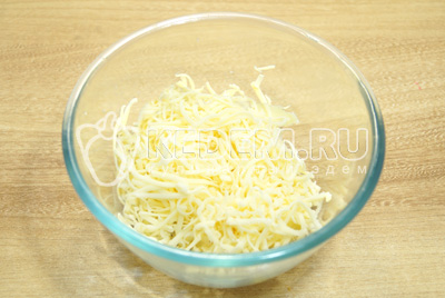 Сыр натереть на терке в миску, чеснок пропустить через пресс.