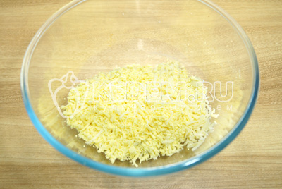 В миске смешать тертые желтки и тертый сыр.