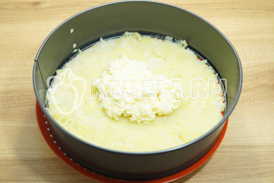 Выложить часть тертого сыра с яйцами и смазать картофель.