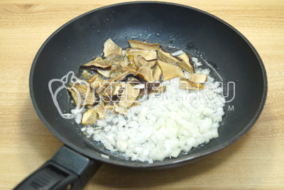 На сковороде обжарить нарезанные грибы и мелко нашинкованный лук, 1-2 минуты.
