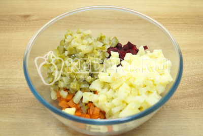 В миску нарезать кубиками свеклу, морковь, картофель и соленые огурцы.