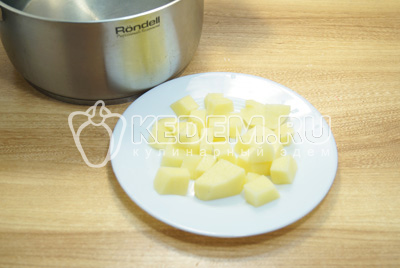 В кастрюле вскипятить воду, картофель очистить и нарезать кубиками, варить 3-5 минут.
