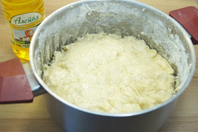 Смазать тесто подсолнечным маслом ТМ «Алейка». Убрать кастрюлю в теплое место на 1 час.