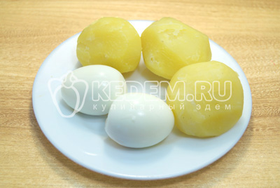 Чтобы приготовить окрошку с колбасой, нужно яйца и картофель отварить, остудить и очистить.