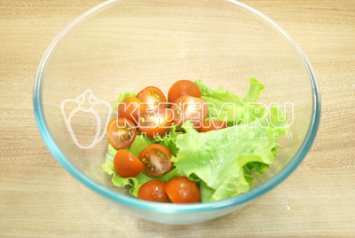 В миску нарвать салат руками, помидоры нарезать на половинки.