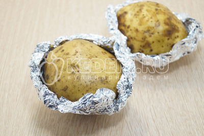 Клубни картофеля хорошо вымыть и завернуть в фольгу. Запекать 20 минут, при 200 градусов С в духовке. Отсудить.