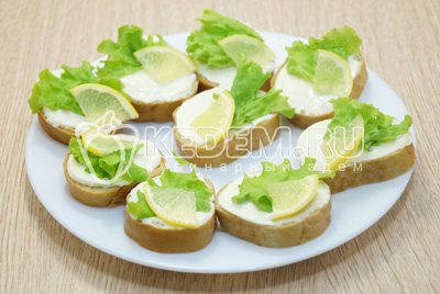 Добавить по небольшому кусочку лимона на каждый бутерброд.
