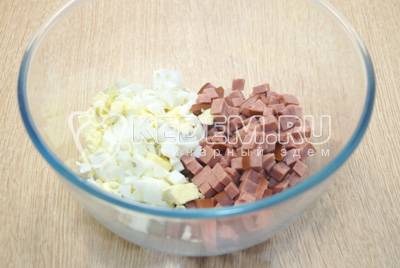 В миску нарезать кубиками отварные яйца и колбасу.