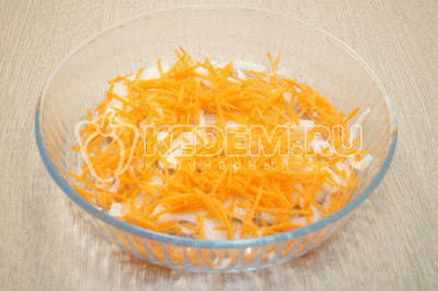 На дно стеклянной формы или контейнера уложить половину овощей, тертую морковь и полукольцами нарезанный лук.