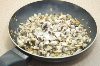 На сковороде с растительным маслом обжарить мелко нашинкованный лук и шампиньоны.Посолить, готовить 4-5 минут.