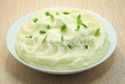 Выложить картофельное пюре на блюдо и украсить зеленью.