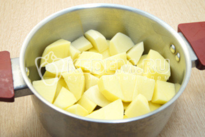 Нарезать картофель на четвертинки и выложить в кастрюлю. Залить водой и поставить варить.