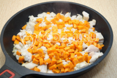 Добавить мелко нашинкованный лук и кубиками нарезанную морковь. Обжарить 2-3 минуты.