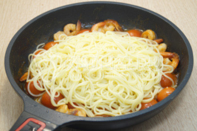 Добавить спагетти в сковороду с креветками и перемешать.
