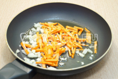 Мелко нашинкованный лук и соломкой нарезанную морковь обжарить на сковороде с растительным маслом, 2-3 минуты.