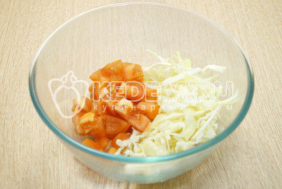 В миску нашинковать капусту и нарезать помидоры кубиками.