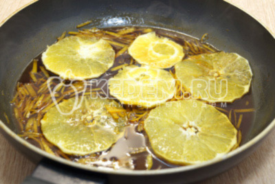 Добавить ломтики апельсина и готовить на медленном огне еще 5-6 минут.