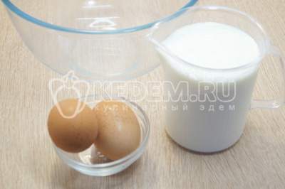 В миске смешать теплое молоко и яйца.