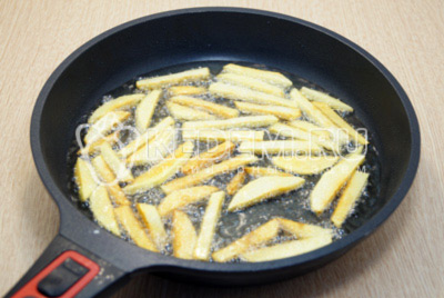 На сковороде разогреть растительное масло и жарить картофельные ломтики частями до золотистой корочки 5-6 минут.