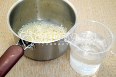 Выложить рис в сотейник и добавить воды. Варить до полу готовности, 10-12 минут на среднем огне помешивая.