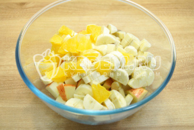 Добавить нарезанные бананы и кубиками нарезанные очищенные апельсины.