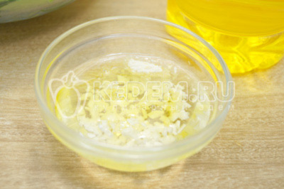 В миску с натуральным нерафинированным подсолнечным маслом ТМ «Алейка» добавить измельченный чеснок.