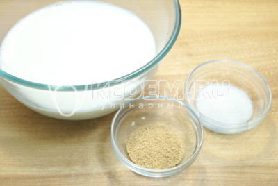 Чтобы приготовить тесто для пирожков на сухих дрожжах, нужно в миску с теплым молоком добавить сухие дрожжи и сахар.
