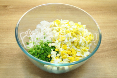 В миске смешать отварной рис, нарубленные отварные яйца и нашинкованный зеленый лук. Перемешать и посолить начинку.
