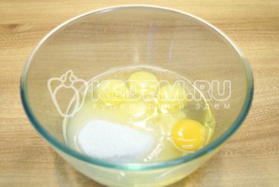 В миску высыпать сахар и добавить яйца. Взбить миксером до растворения сахара.