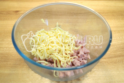 В миску натереть сыр и кубками нарезать колбасу, перемешать.