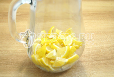 Нарезать лимоны ломтиками и сложить в кувшин.