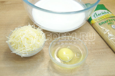 В миску влить 100 мл сливок, добавить 1 яйцо и 50 г тёртого сыра Пармезан. Хорошо перемешать и немного посолить.