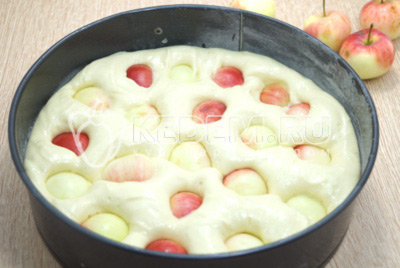 Яблоки разрезать на половинки или четвертинки и удалить сердцевину. Добавить яблоки в тесто.