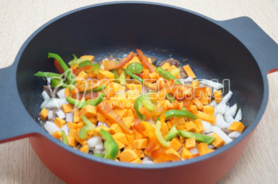 Добавить нарезанный соломкой болгарский перец и кубиками нарезанную морковь.