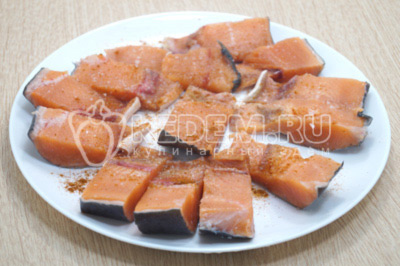 Кусочки рыбы посолить и приправить молотым красным перцем по вкусу.