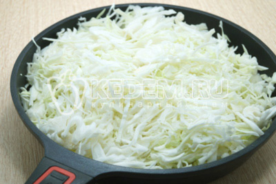Выложить нашинкованную капусту в сковороду и обжарить 10-12 минут на среднем огне, помешивая.