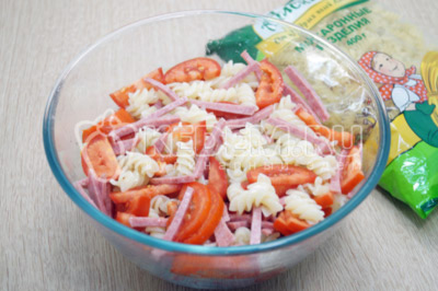 Перемешать отварные макароны ТМ «Алейка» с помидорами и салями.