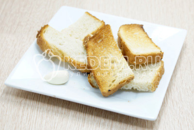 Подсушить ломтики хлеба в тостере или духовке. Очистить зубчик чеснока, натереть подсушенные ломтики хлеба чесноком.
